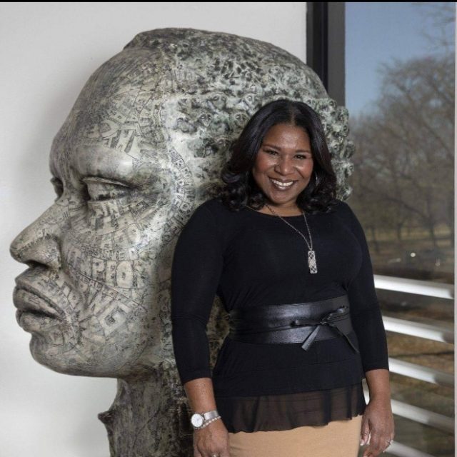 Chicagoan of the Year Tammy McCann stands next to the sculpture "Deeply Rooted (Dr. Martin Luther King)," a piece by artist Frank Hayden, at the DuSable Museum of African American History Wednesday, Dec. 9, 2020, in Chicago.
